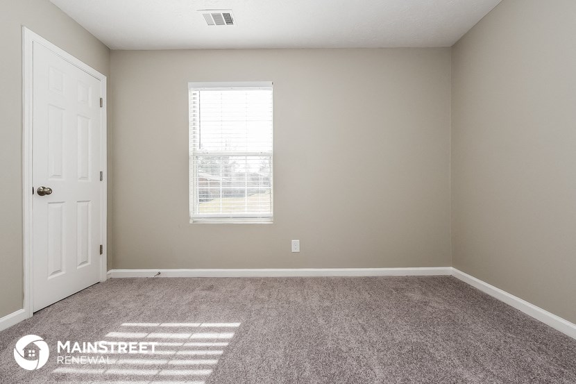 an empty room with carpet and a window