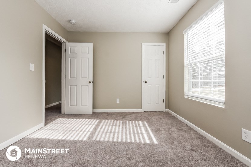 the master bedroom has carpeted flooring and a large window