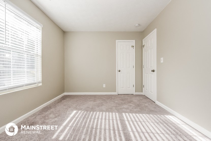 an empty room with a door and a window