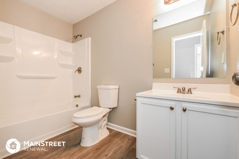 a bathroom with a toilet sink and tub and a mirror