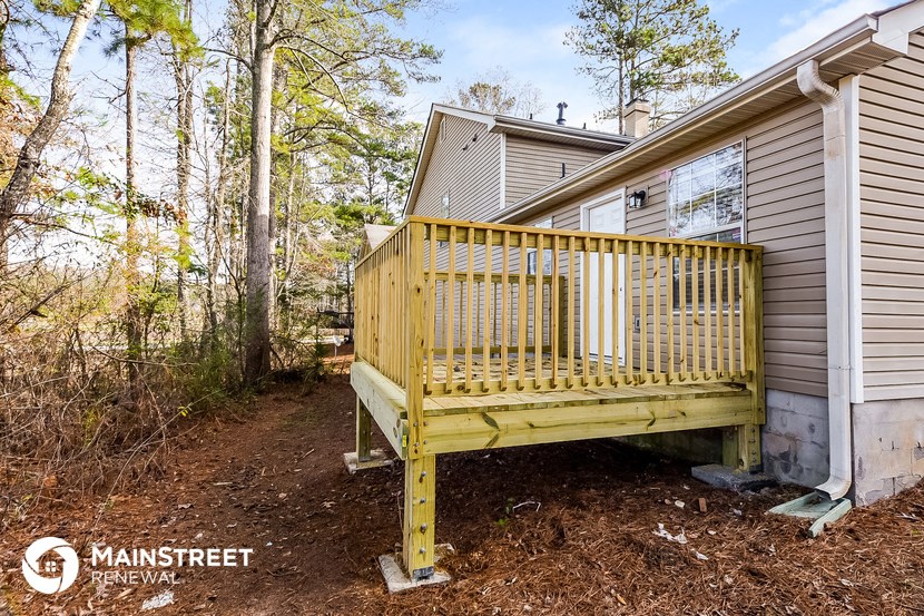 a porch with a yellow bench in front of a house