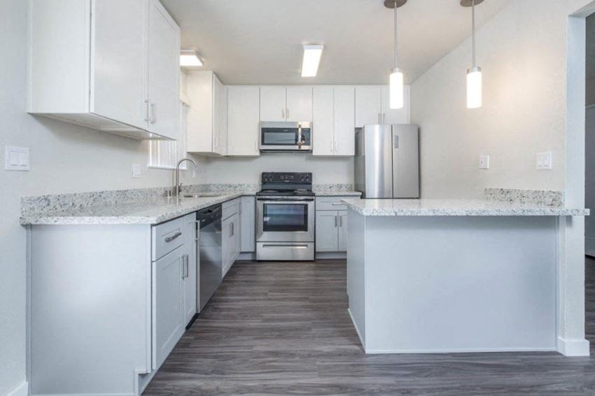 Kitchen Alternate view of kitchen with stone counters, white cabinets, stainless appliances