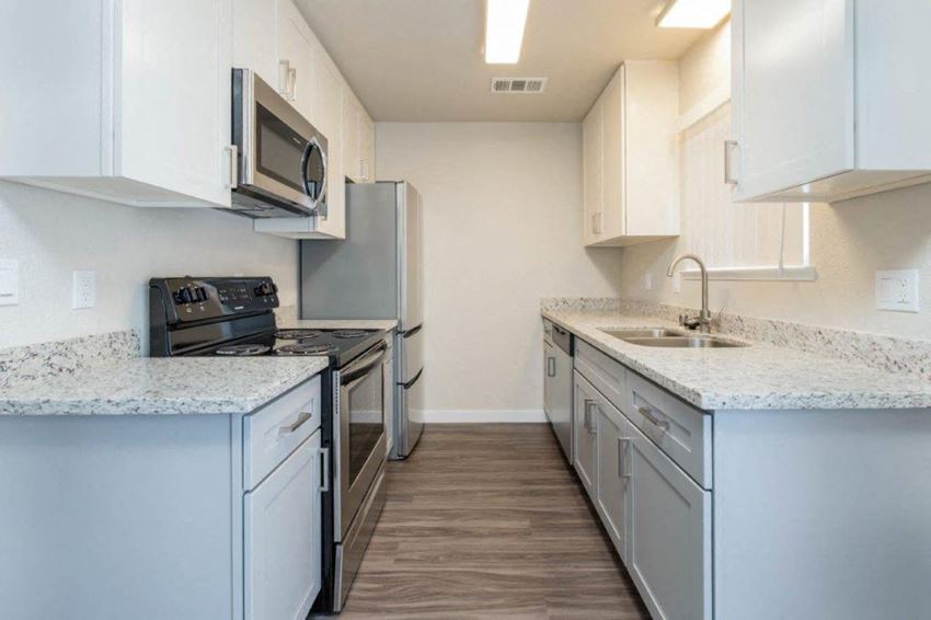Kitchen Alternate view of kitchen with stone counters, white cabinets, stainless appliances