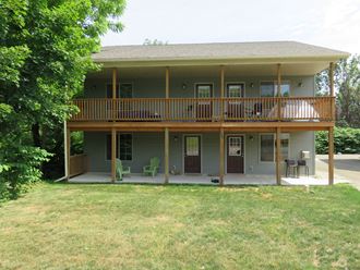 the front of the house with a deck and a wrap around porch