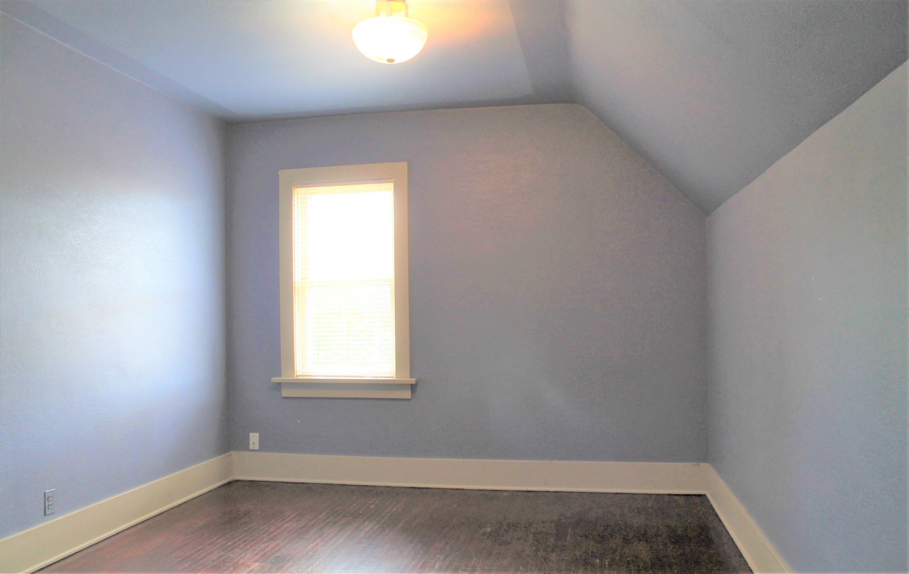 an empty room with blue walls and a window