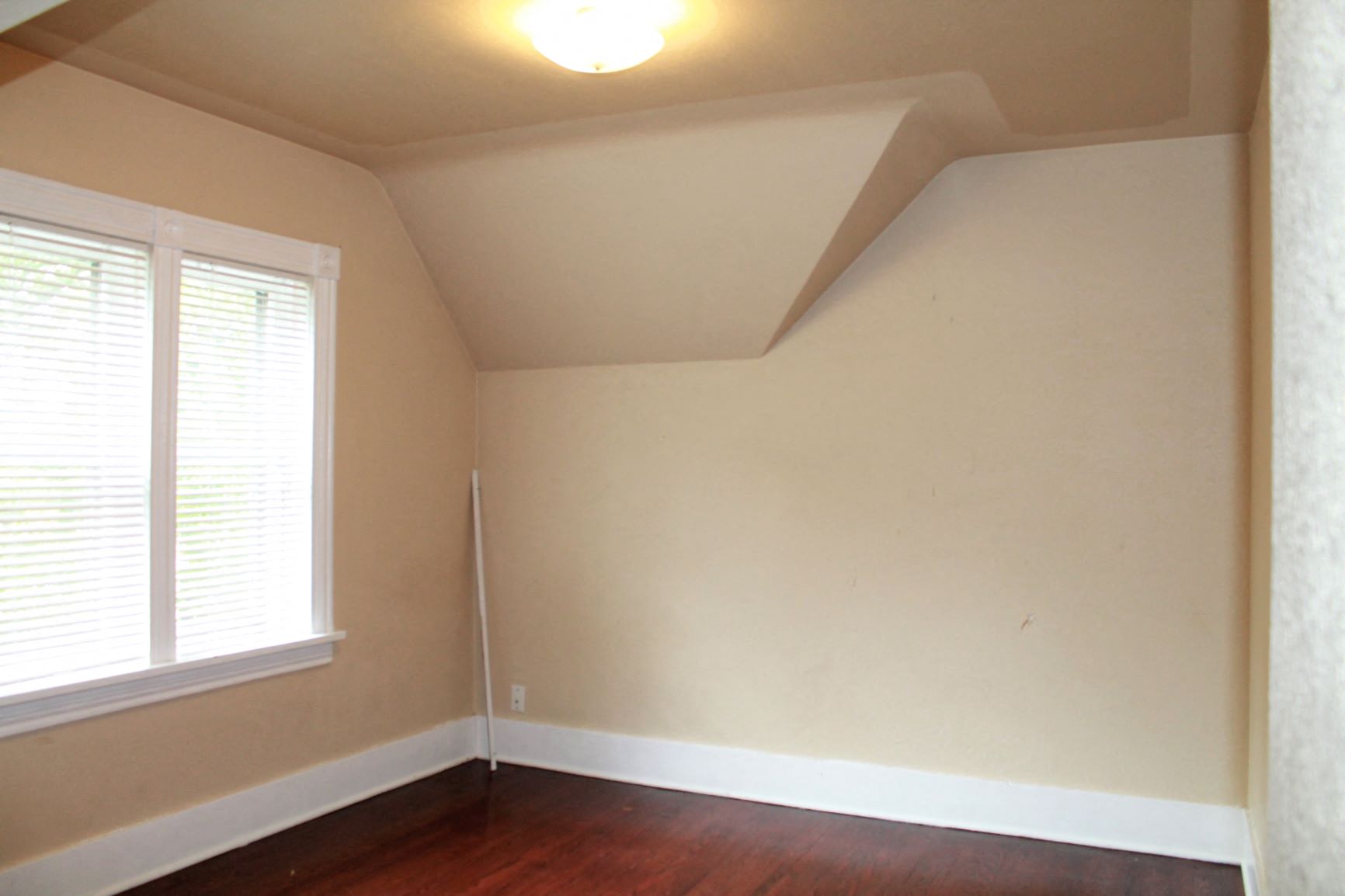 an empty room with a wooden floor and a window
