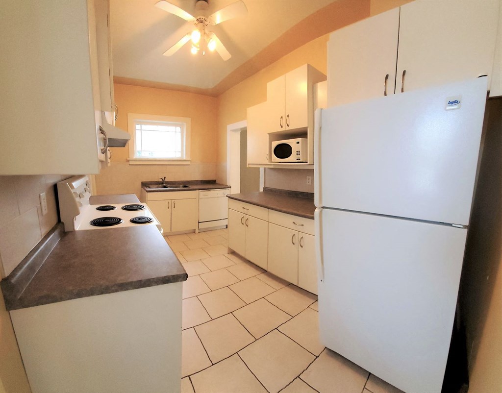 a kitchen with a white refrigerator and a stove
