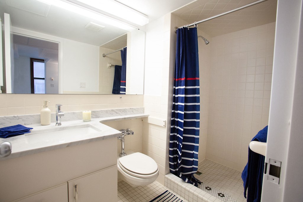 a bathroom with a toilet and a sink and a shower