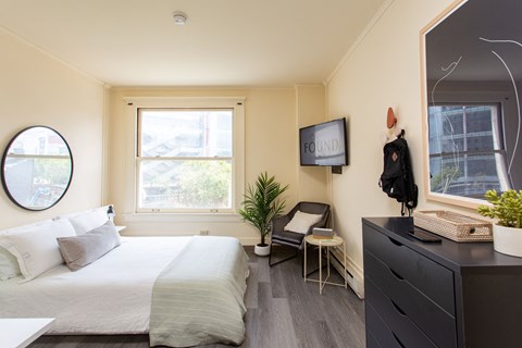 a bedroom with a bed and a dresser and a window