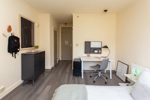 a bedroom with a bed and a desk with a chair