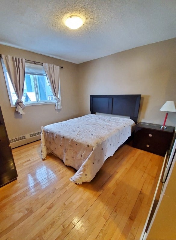 a bedroom with a bed and a wooden floor