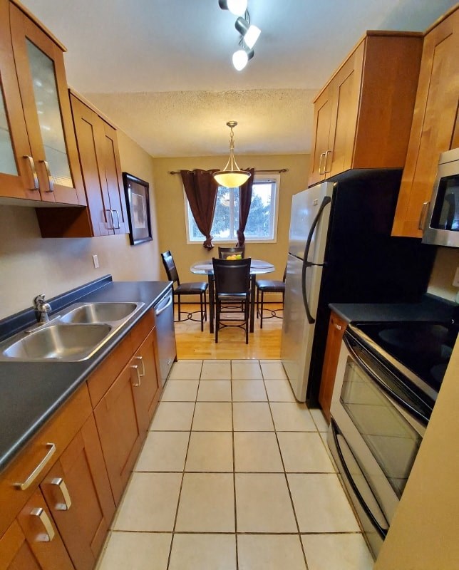 a kitchen with a table and a refrigerator and a sink