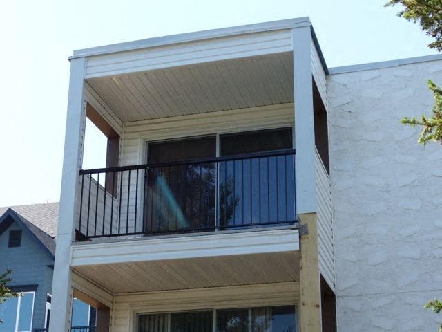 a balcony on the top of a white house