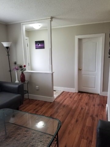 A living room with a glass table and a grey couch.