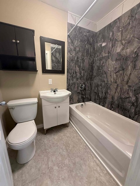 A bathroom with a toilet, sink, and bathtub.