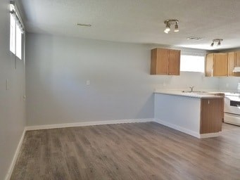A kitchen area with a white countertop and wooden cabinets.