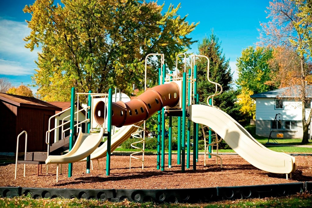 A playground with a slide and a climbing structure.