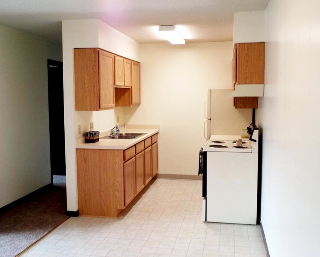 A kitchen with wooden cabinets and a white dishwasher.