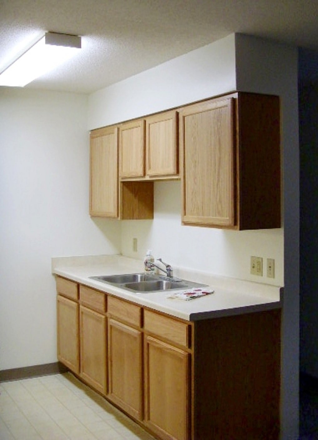A kitchen with wooden cabinets and a white counter.