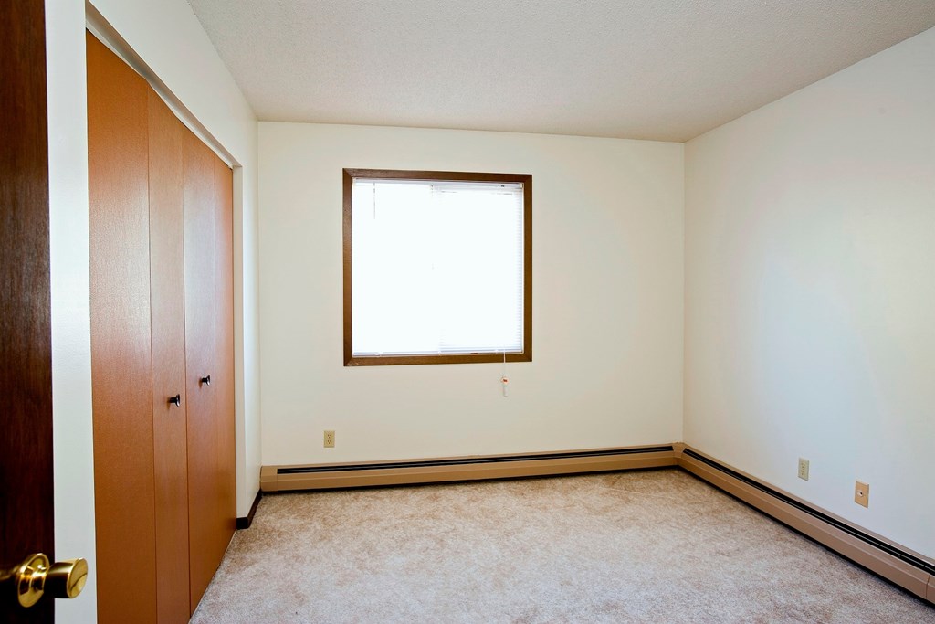 A room with a brown door and a window.
