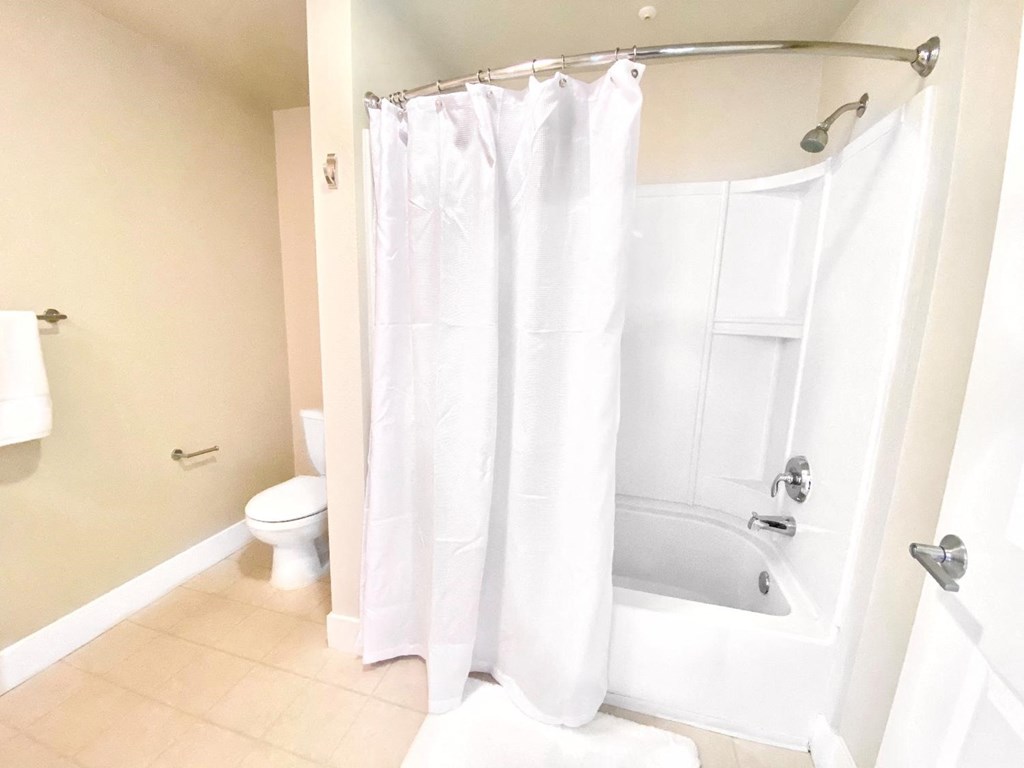 a bathroom with a shower and a toilet and a shower curtain