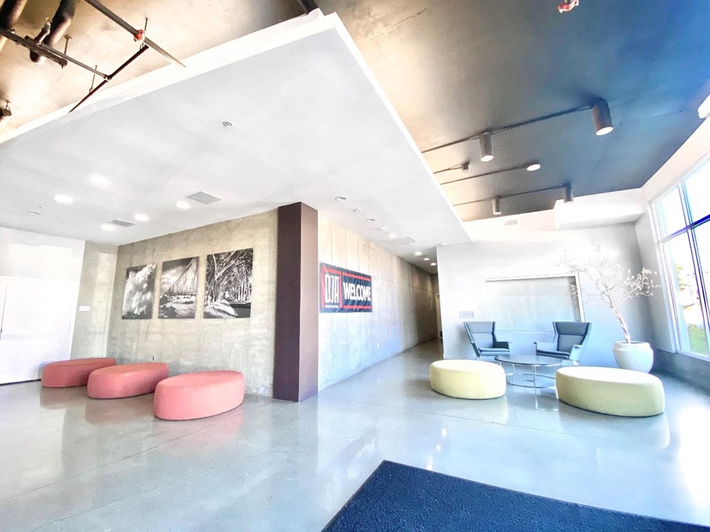 a lobby with couches and chairs and a wall with pictures