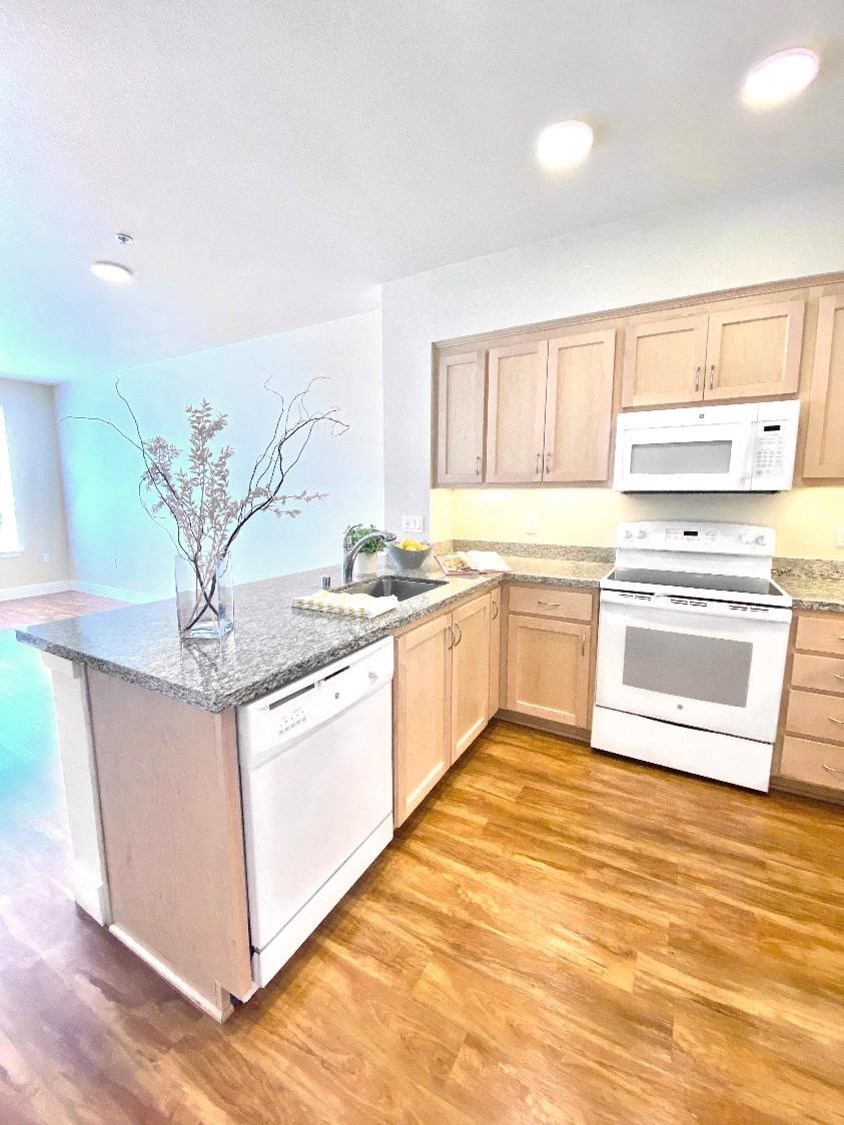 a kitchen with wooden floors and white appliances