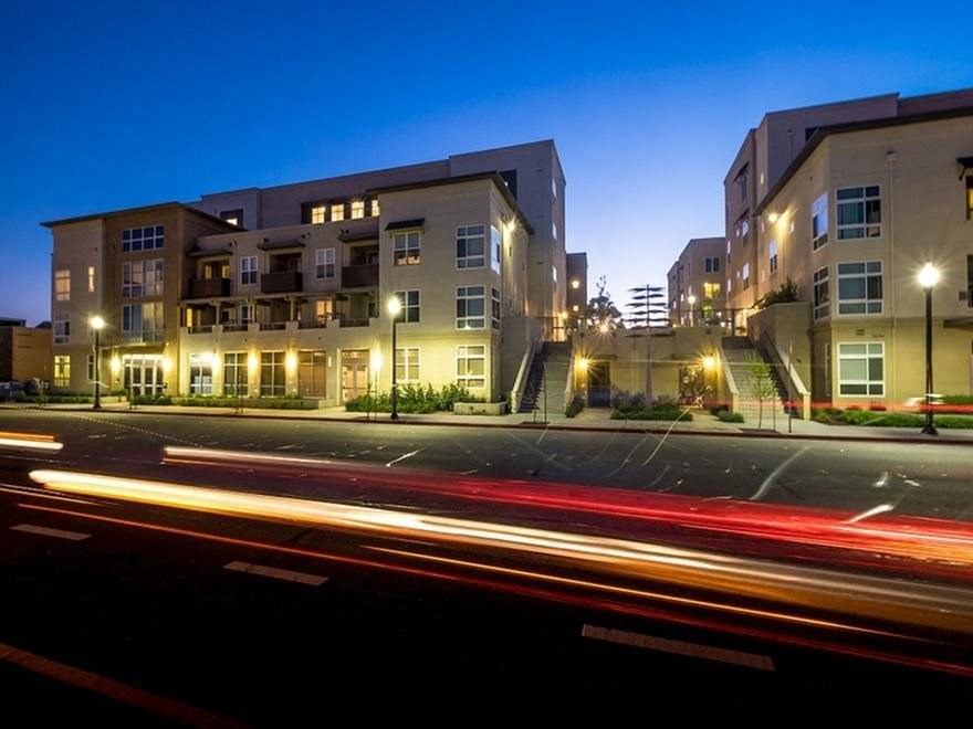 an apartment building on a city street at night