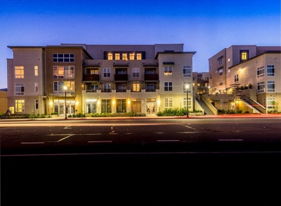 an evening view of an apartment building on a city street