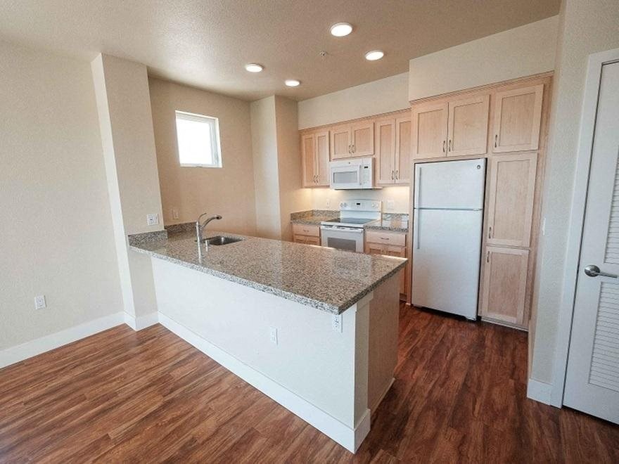 an empty kitchen with a granite counter top