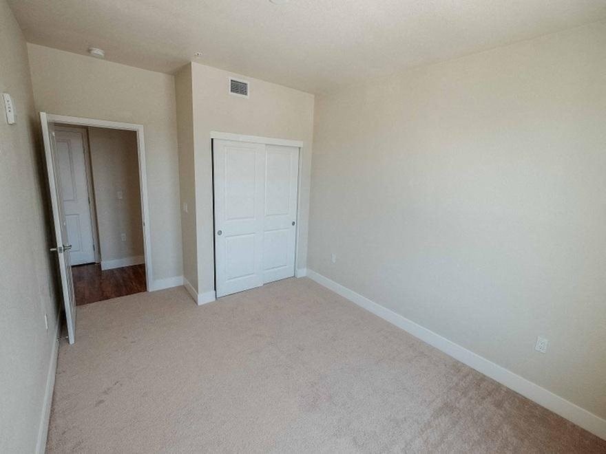an empty living room with a door to a closet