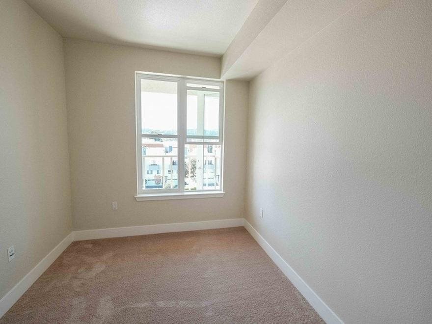 an empty room with a window and carpet