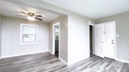 an empty living room with a ceiling fan
