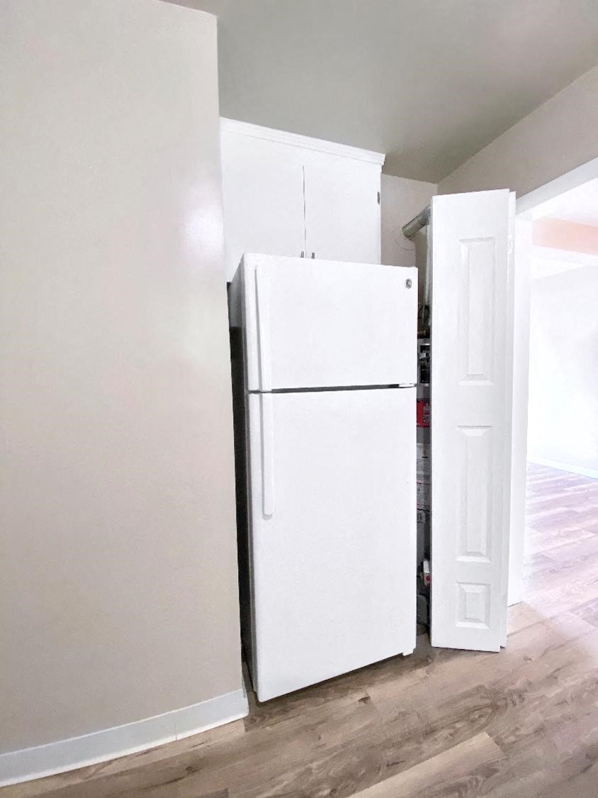 a white refrigerator in a room with a door