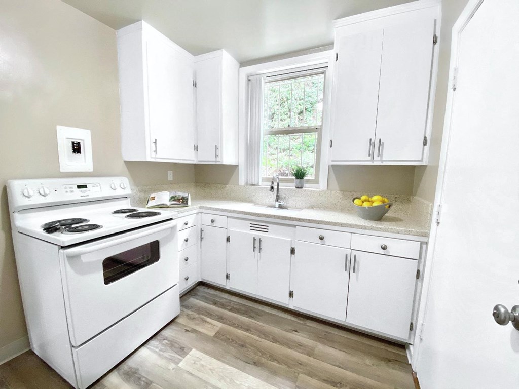 a white kitchen with white appliances and white cabinets