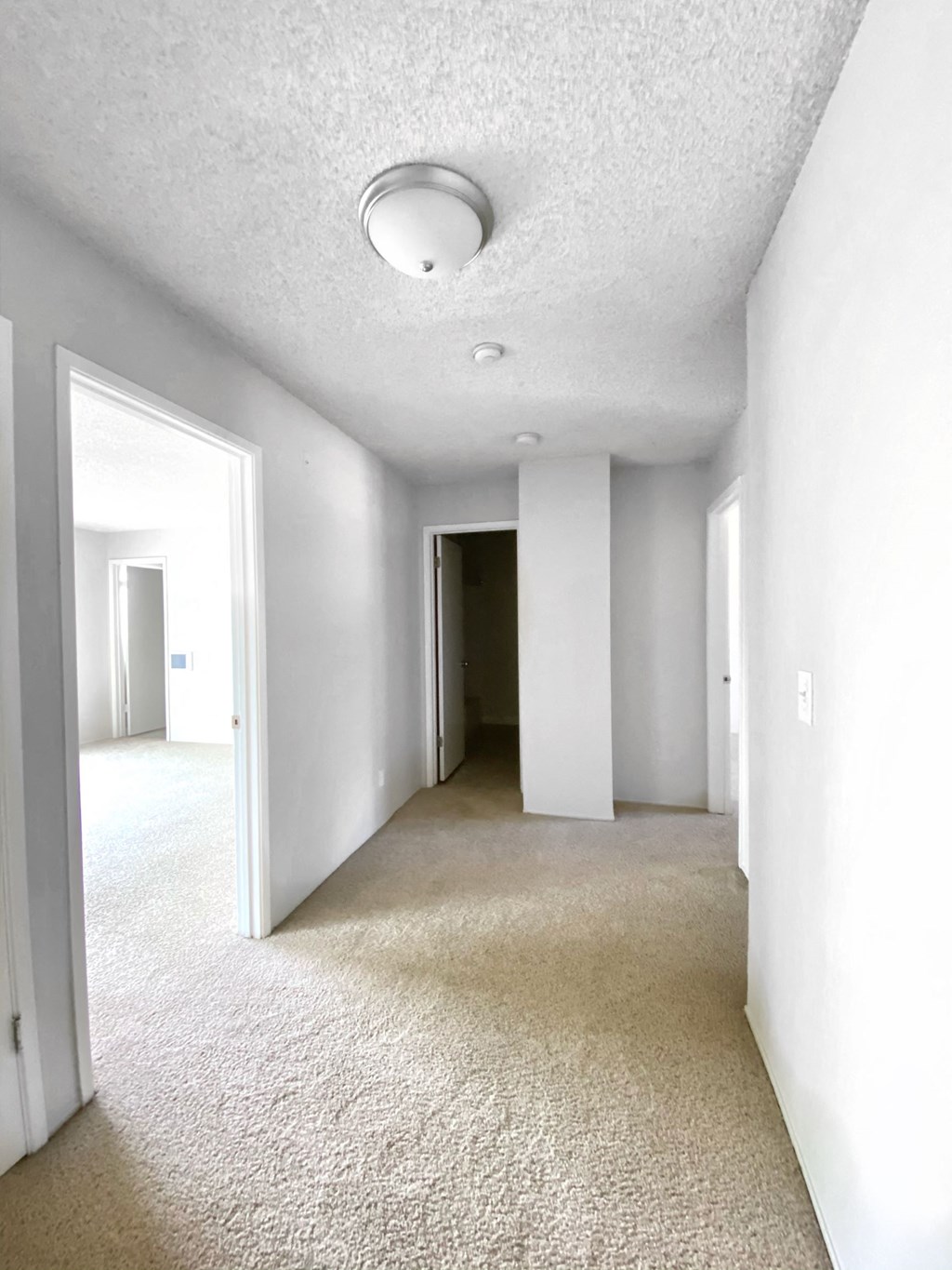 an empty room with a carpeted floor and white walls