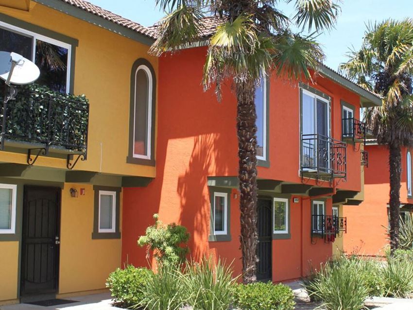 an orange house with palm trees in front of it