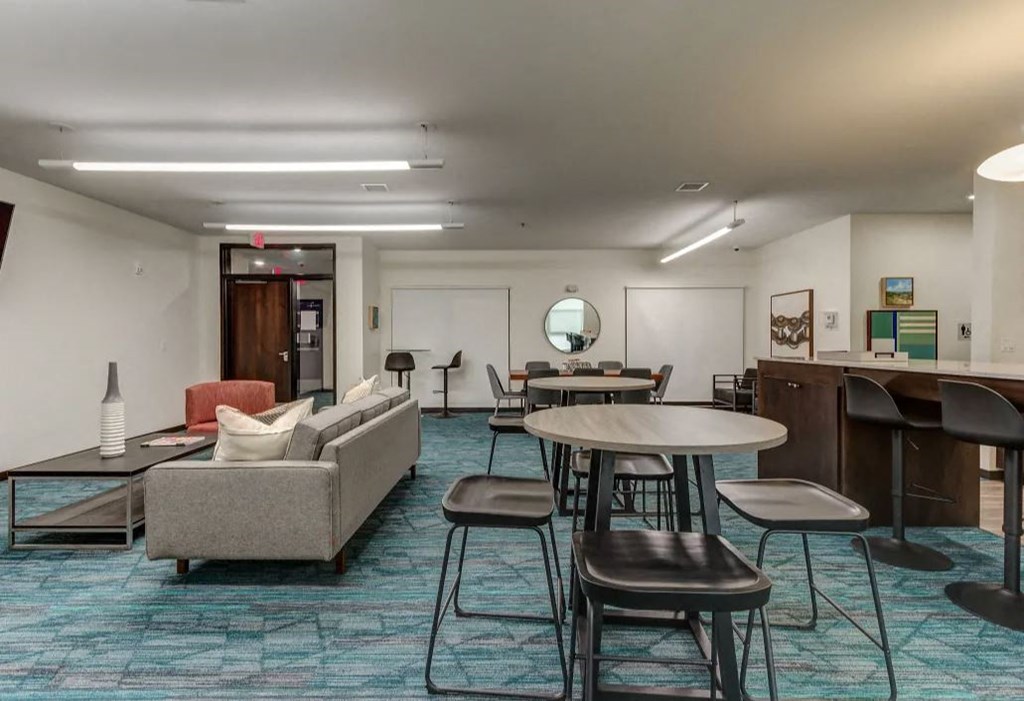 a lounge area with tables and chairs in a lobby