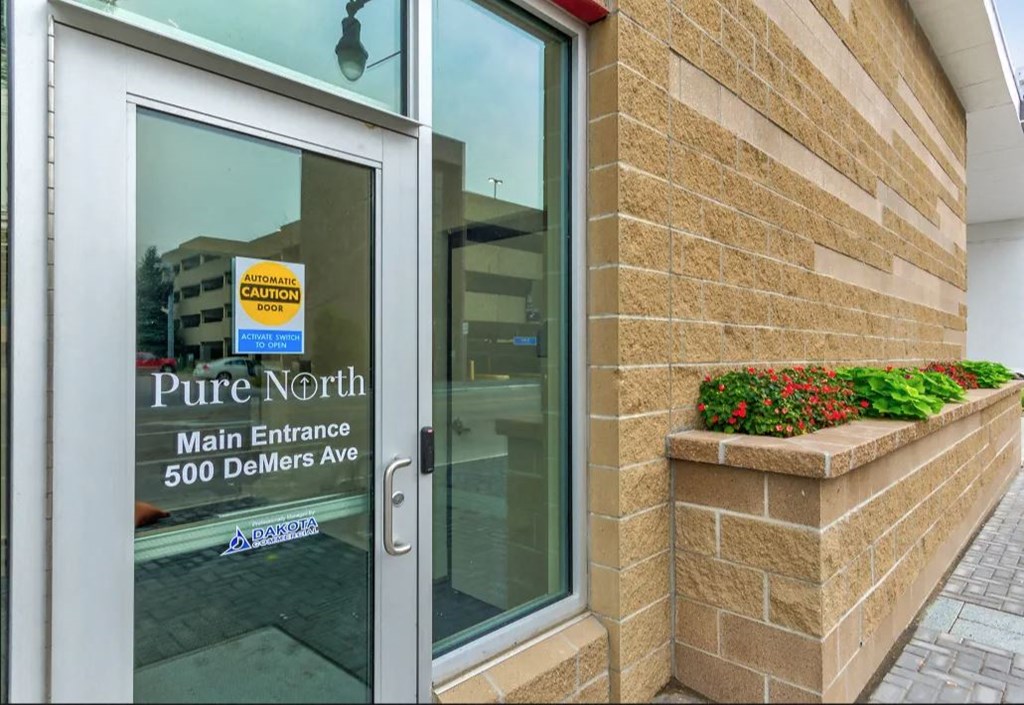 pure north main entrance sign on the door of a building