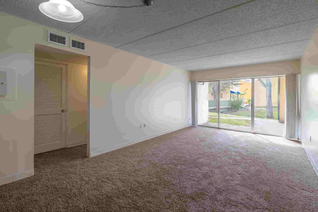 an empty living room with a door to a patio