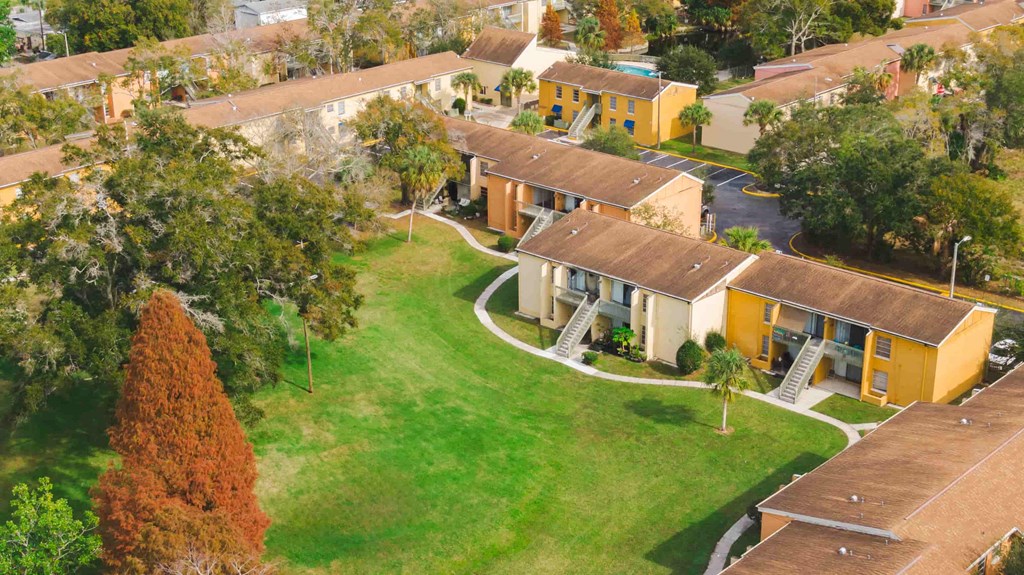 an aerial view of houses in a neighborhood with grass and trees