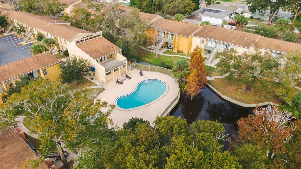 an aerial view of a swimming pool in front of a house