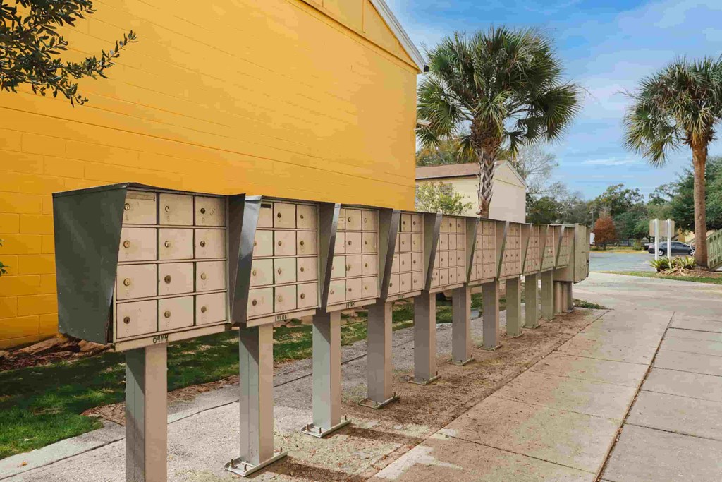a row of mailboxes in front of a yellow building