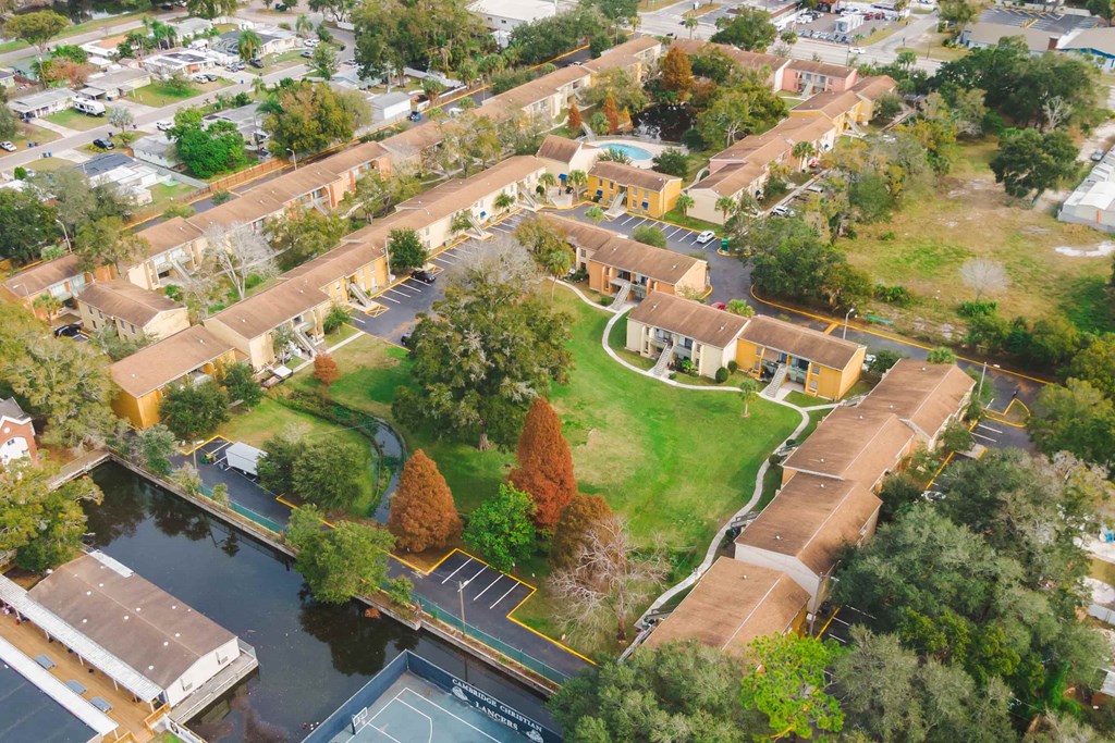 an aerial view of a neighborhood with houses and a body of water