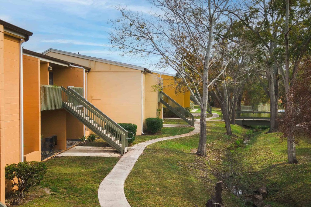 an exterior view of a building with trees and a pathway
