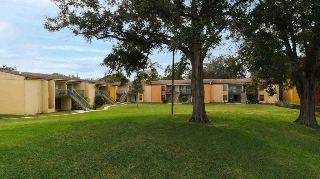 an exterior view of a building with grass and trees