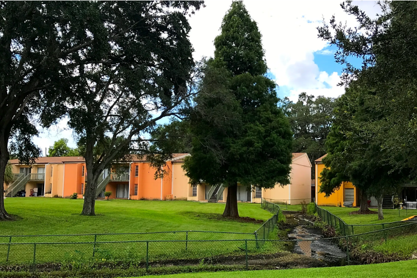 a group of houses in a park with trees