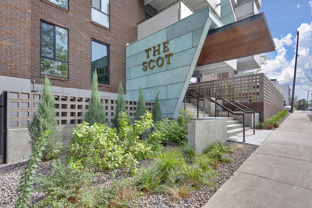 the facade of the scott building with plants in front of it