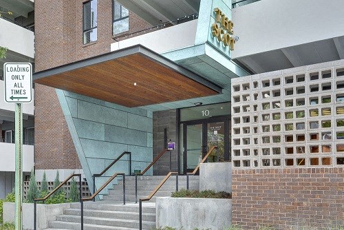 the front of a building with stairs and a glass door