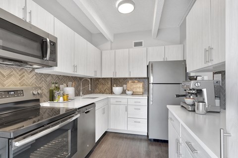 a kitchen with stainless steel appliances and white cabinets